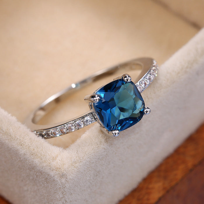 Anillo de mujer con microincrustaciones de circonitas y zafiro con diamantes azules