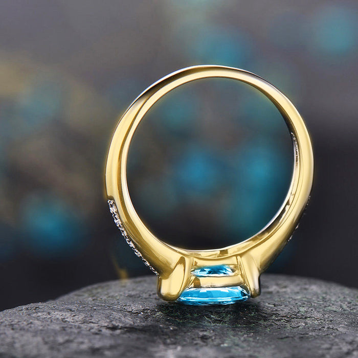 Anillo bañado en oro con zafiro y circonita microengastada