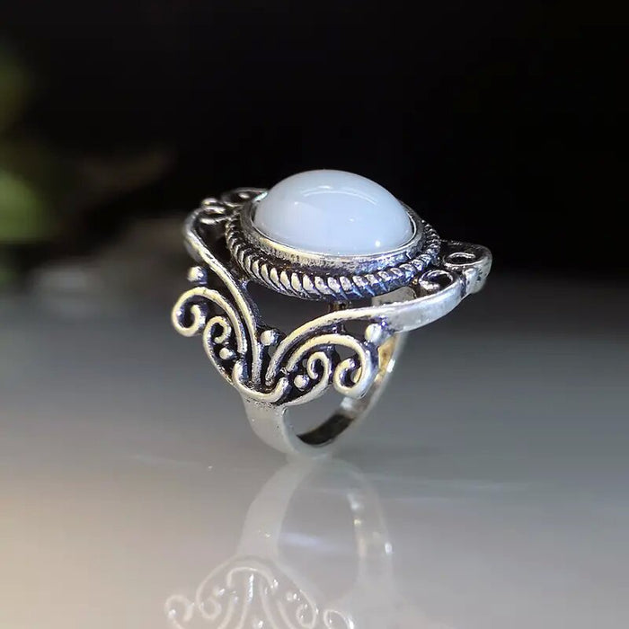 Ring with geometric hollow carvings inlaid with imitation moonstone