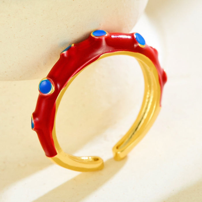 Wholesale gold-plated copper rings with colored droplets and geometric open designs.