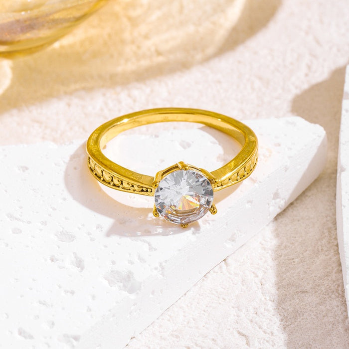 Wholesale 18K gold-plated titanium steel patterned rings set with a single zircon.