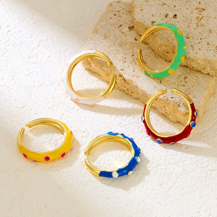 Wholesale gold-plated copper rings with colored droplets and geometric open designs.