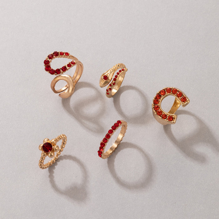 Juego de 5 anillos rojos con forma de serpiente y letras irregulares