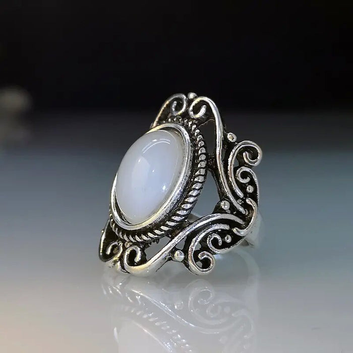 Ring with geometric hollow carvings inlaid with imitation moonstone