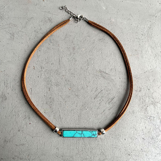 Collar minimalista de vaquero occidental con colgante geométrico de turquesa sobre cordón de cuero