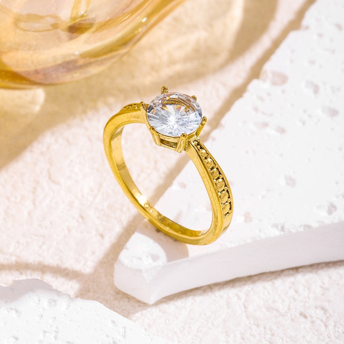 Wholesale 18K gold-plated titanium steel patterned rings set with a single zircon.