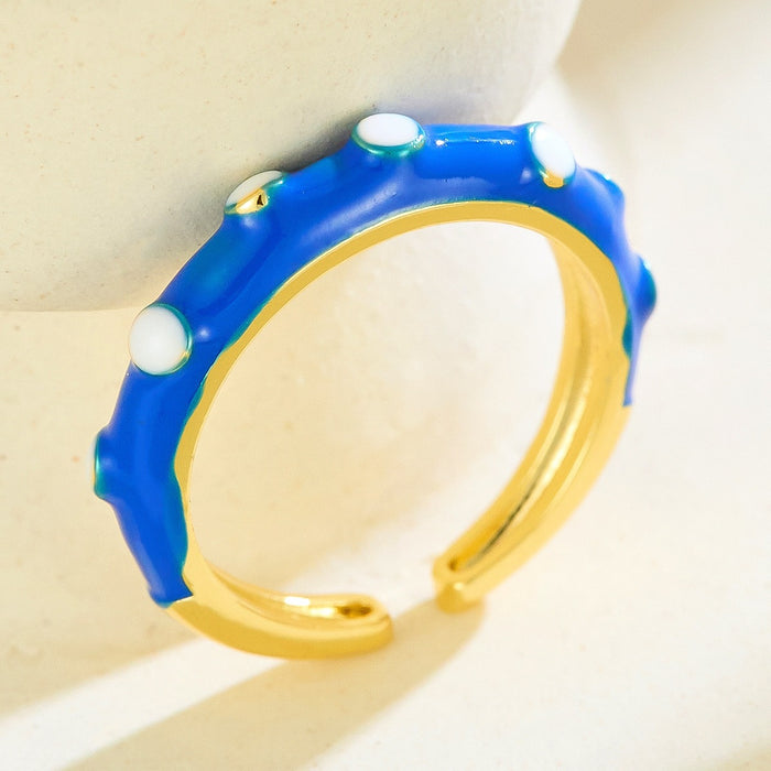 Wholesale gold-plated copper rings with colored droplets and geometric open designs.
