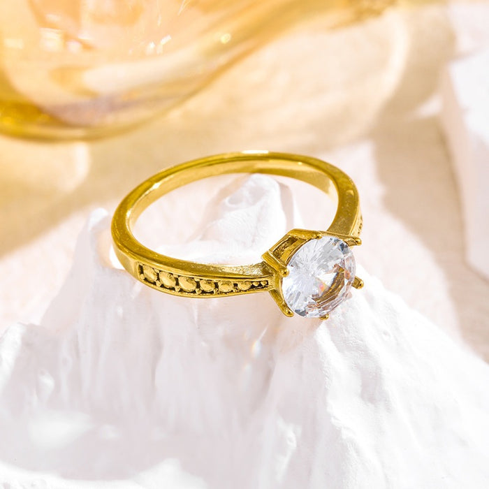 Wholesale 18K gold-plated titanium steel patterned rings set with a single zircon.
