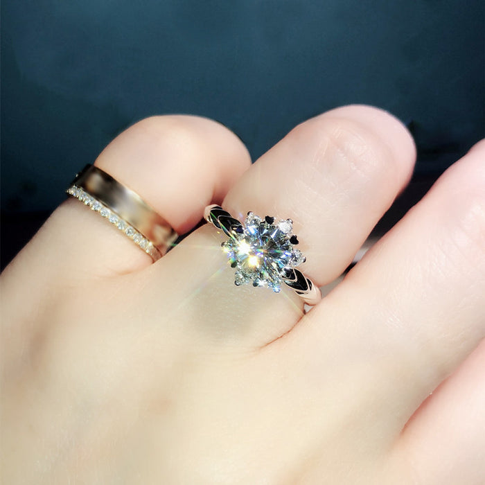 Anillo de compromiso con flor bañado en oro blanco y brazo retorcido con copo de nieve