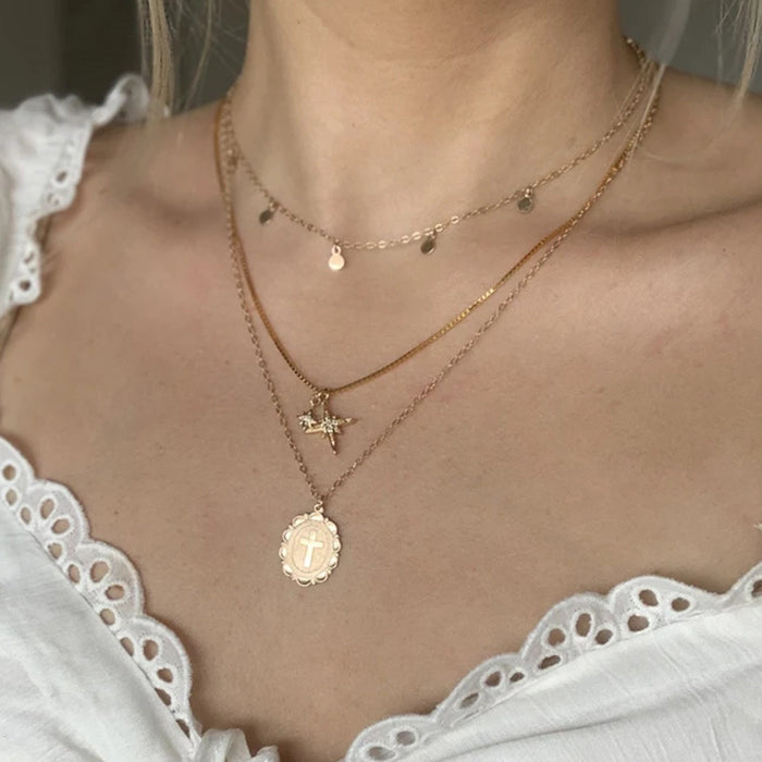 Gold cross necklace can be worn in multiple layers with clavicle chain